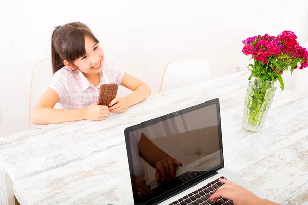 Daughter eating chocolate at home — Stock Photo, Image